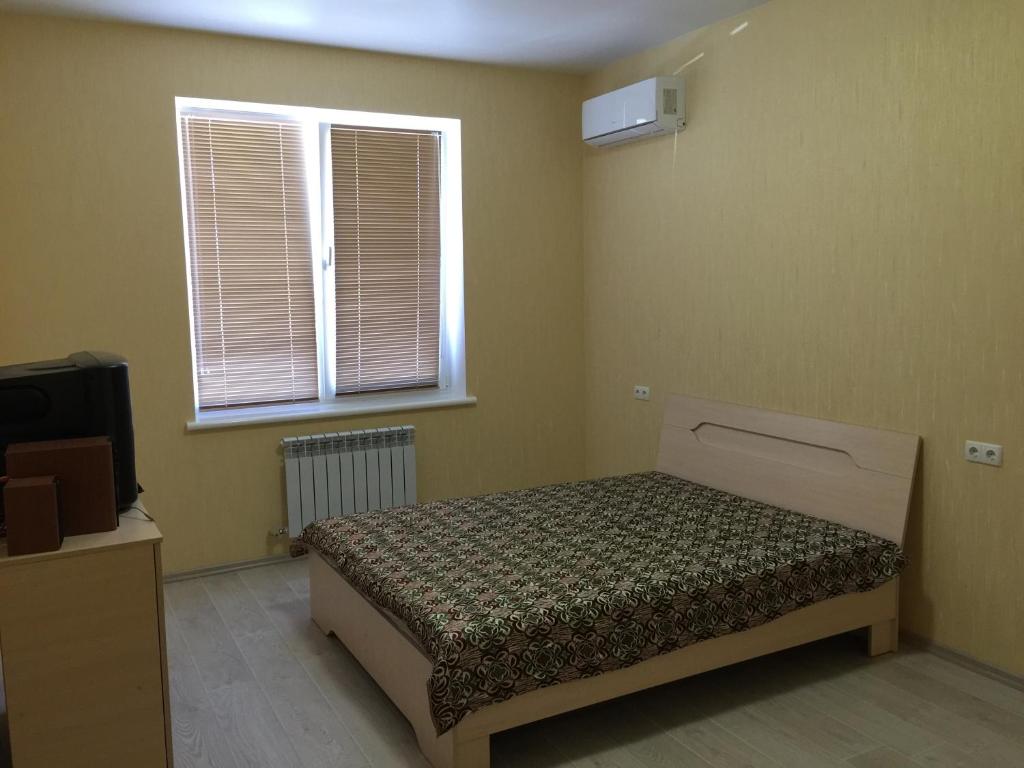 een slaapkamer met een bed voor een raam bij Apartment on Parusna in Chornomorsk