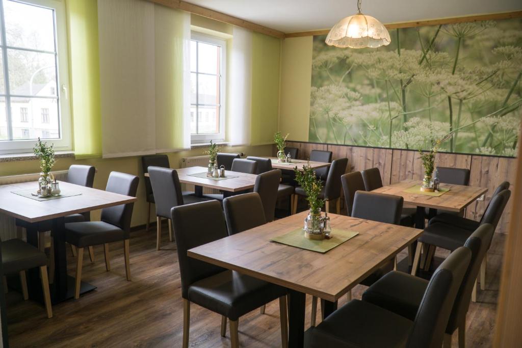 a restaurant with tables and chairs and a large painting on the wall at Pension & Reitstall Inghofer in Heidenreichstein
