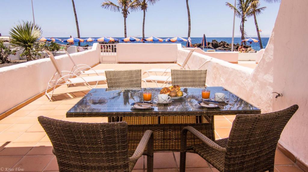 a table and chairs on a balcony with the beach at Villa Sontrobat in Puerto del Carmen