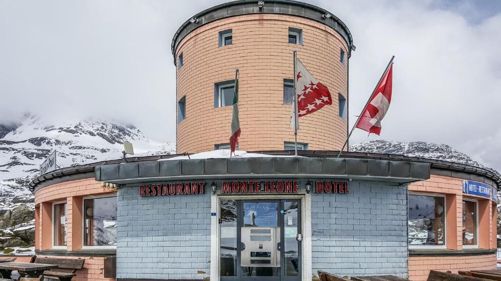 un edificio con una torre de reloj encima en Hotel Restaurant Monte Leone, en Simplon Dorf