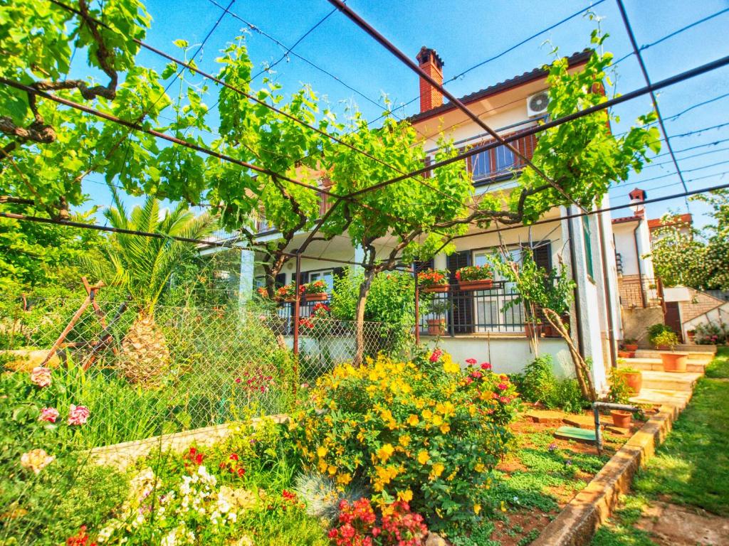 a garden in front of a house with flowers at Apartment Patricija 1208 in Banjole
