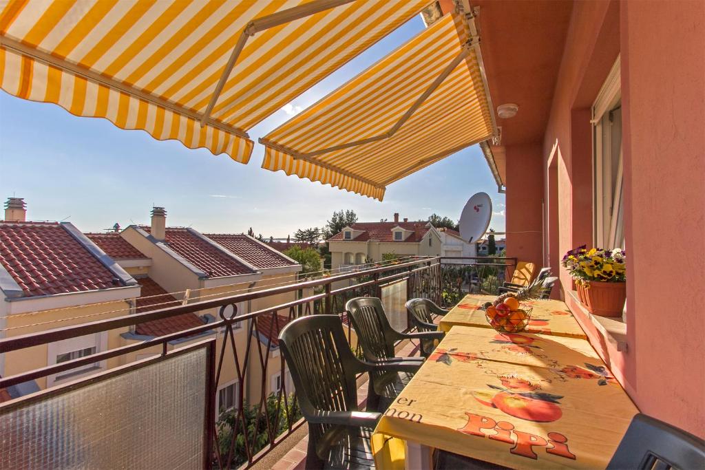 Un balcón con mesas y sillas y vistas. en Nella, en Zadar