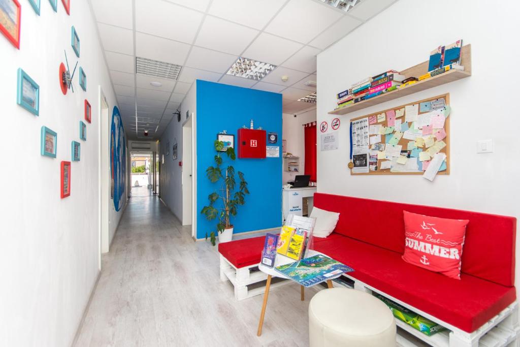 a room with a red bench and a blue wall at Hostel Petra Marina in Dubrovnik