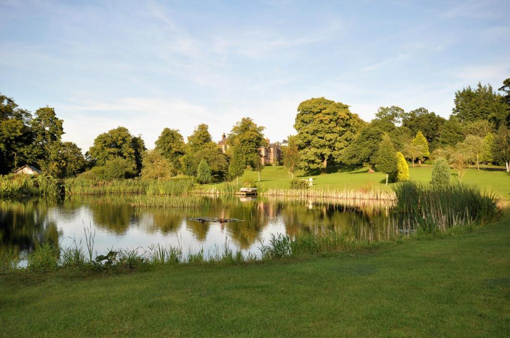 uma vista para um lago num parque com árvores em Carnell Country Estate em Hurlford