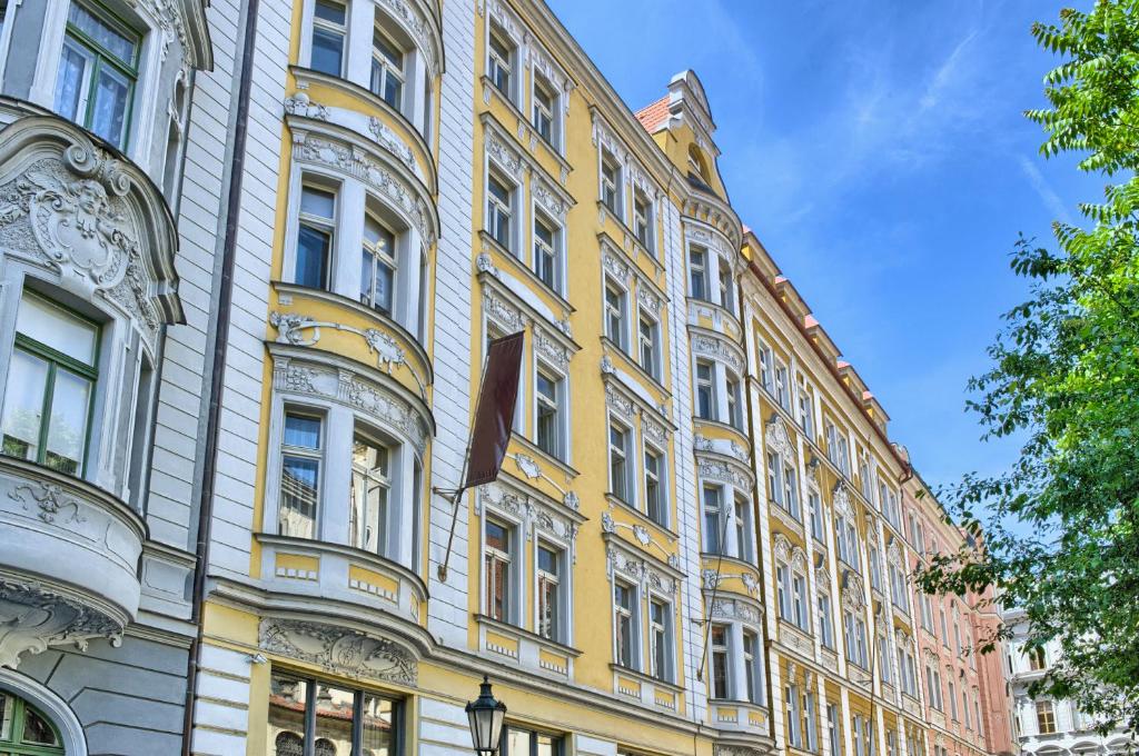 a yellow building with white windows on a street at Milosrdnych Apartments in Prague