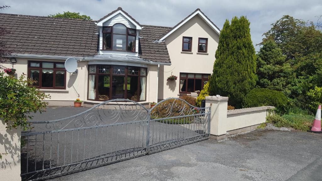 a white house with a gate in front of it at Tulla Villa Self Catering in Riverstown