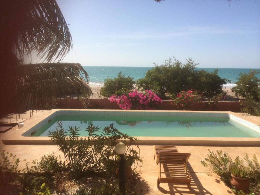 een zwembad met uitzicht op de oceaan bij la villa sur la plage in Palmarin