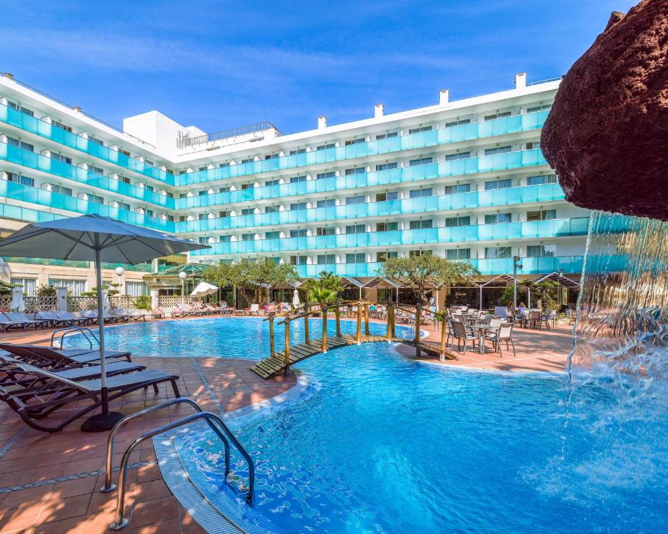 un hotel con piscina frente a un edificio en H10 Delfín - Adults Only, en Salou