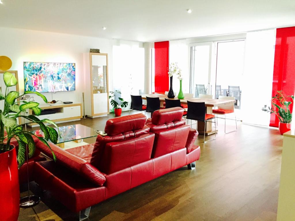 a living room with a red couch and a table at Rhein Melodie riverview luxury in Konstanz