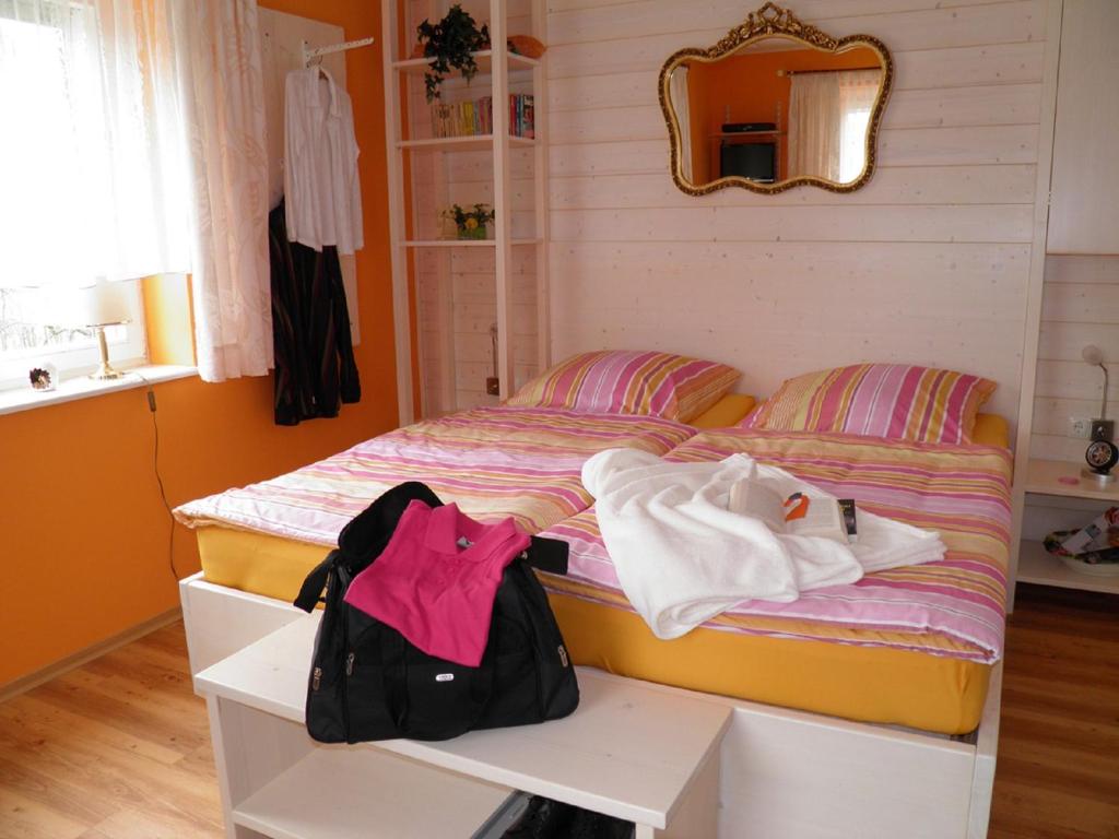 a bedroom with a bed with a bag on it at B&B Brandholz in Goldkronach