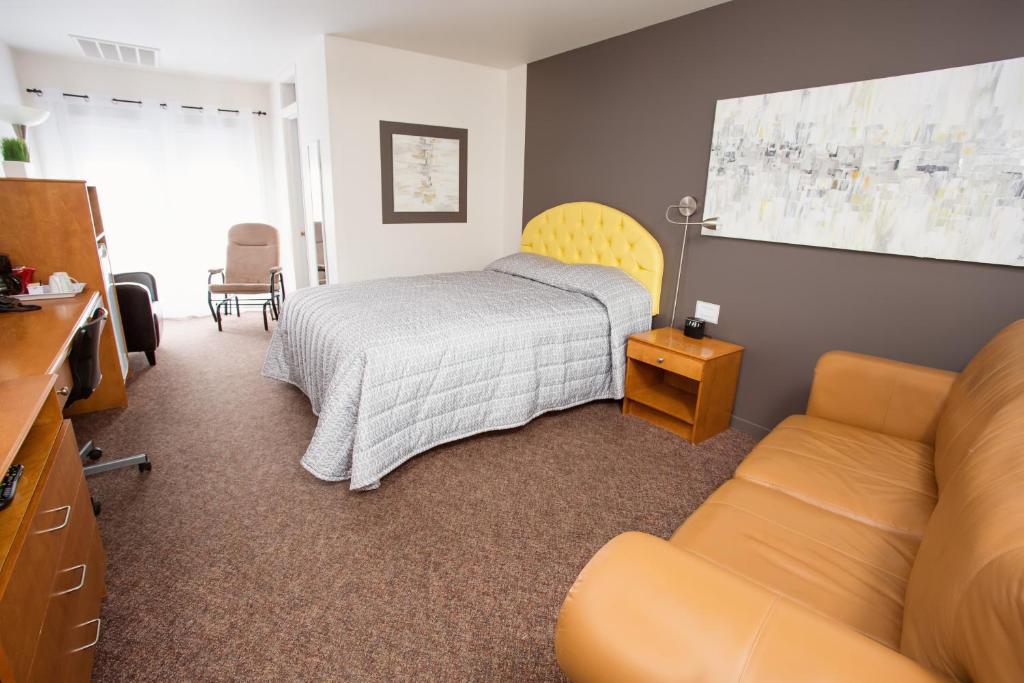 - une chambre avec un lit et un canapé dans l'établissement Motel Blanche d'Haberville, à Saint-Jean-Port-Joli