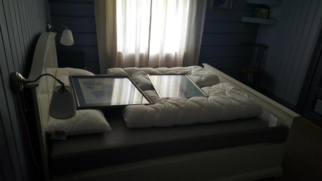 a bed with a laptop on top of it at Eidsfoss slusevokterbolig in Lunde