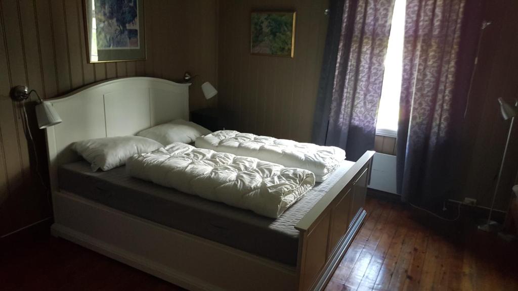 a bed with pillows on it in a room at Eidsfoss slusevokterbolig in Lunde