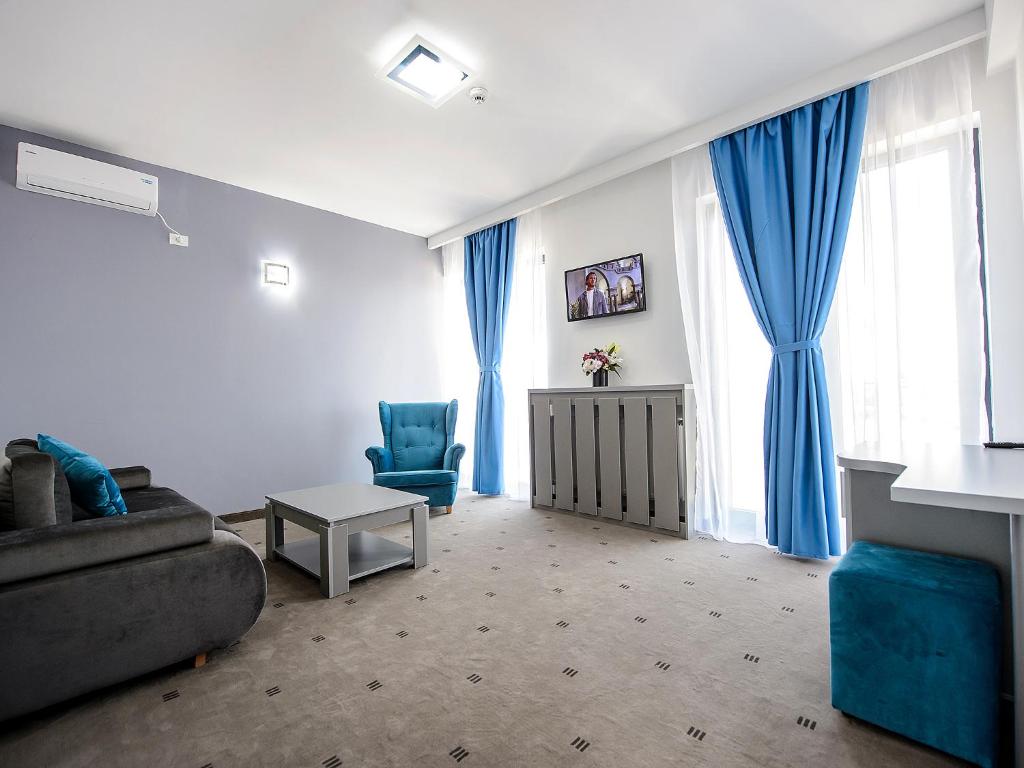 a living room with a couch and a chair at Vila La Mer Mamaia Nord in Mamaia Nord