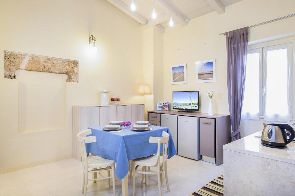 uma sala de jantar com uma mesa azul e cadeiras em Iolanda Apartment 30m from Seaside em Alghero