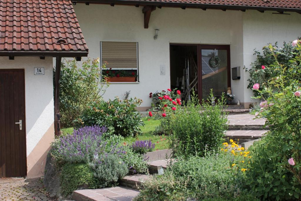 un jardín frente a una casa con flores en Ferienwohnung Ausblick, en Weißensberg