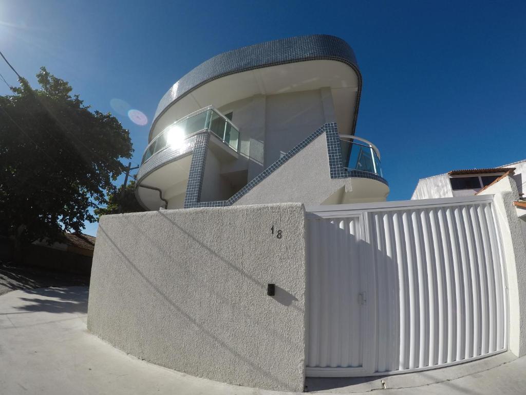 un edificio con una valla blanca delante de él en Temporada - Cabo Frio, en Cabo Frío