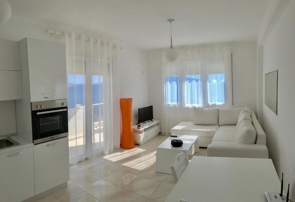 un soggiorno bianco con divano e TV di White Residence Apartament a Sarandë