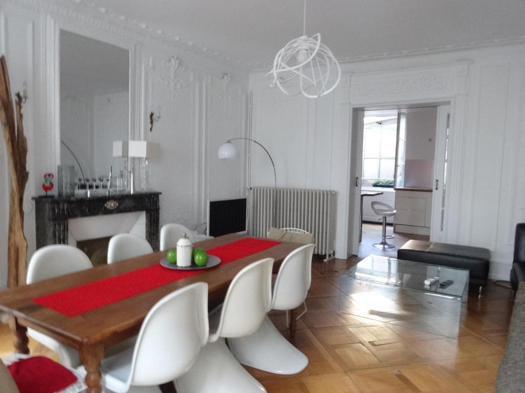 ein Wohnzimmer mit einem Esstisch und Stühlen in der Unterkunft Les Serruriers - Appartement Spacieux avec Terrasse & Parking in Straßburg
