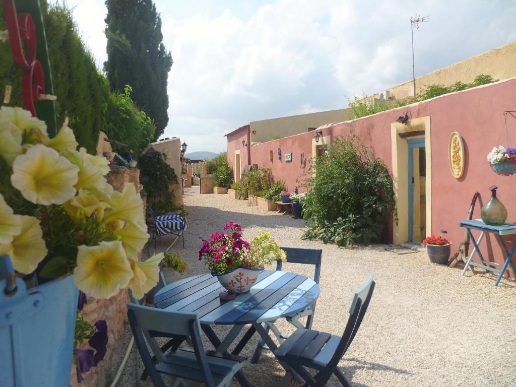 a blue table and chairs in a courtyard with flowers at Casa Rural Ubeda Pinoso-Alicante in Úbeda