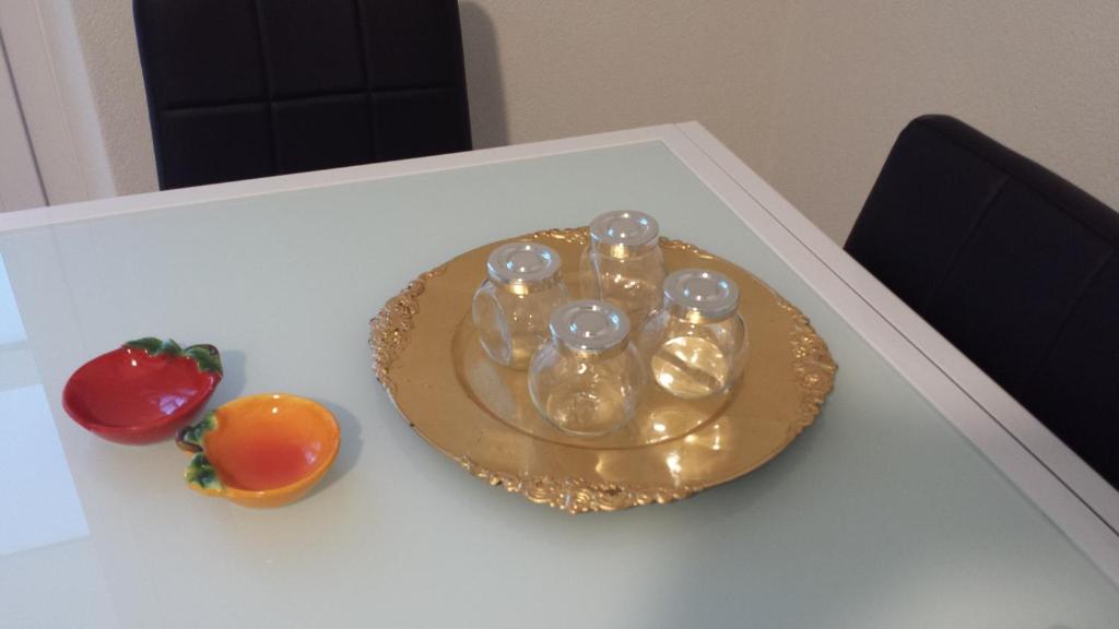 un piatto con quattro bottiglie e un pomodoro su un tavolo di Residenza Lux fronte mare a Vado Ligure