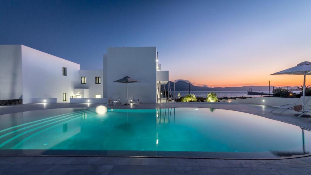 a swimming pool in a villa at night at Olea Bay Hotel in Adamantas