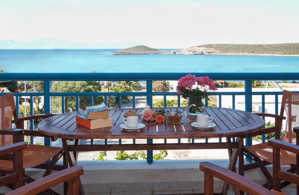 a table on a balcony with a view of the ocean at Athena Kythera in Diakofti