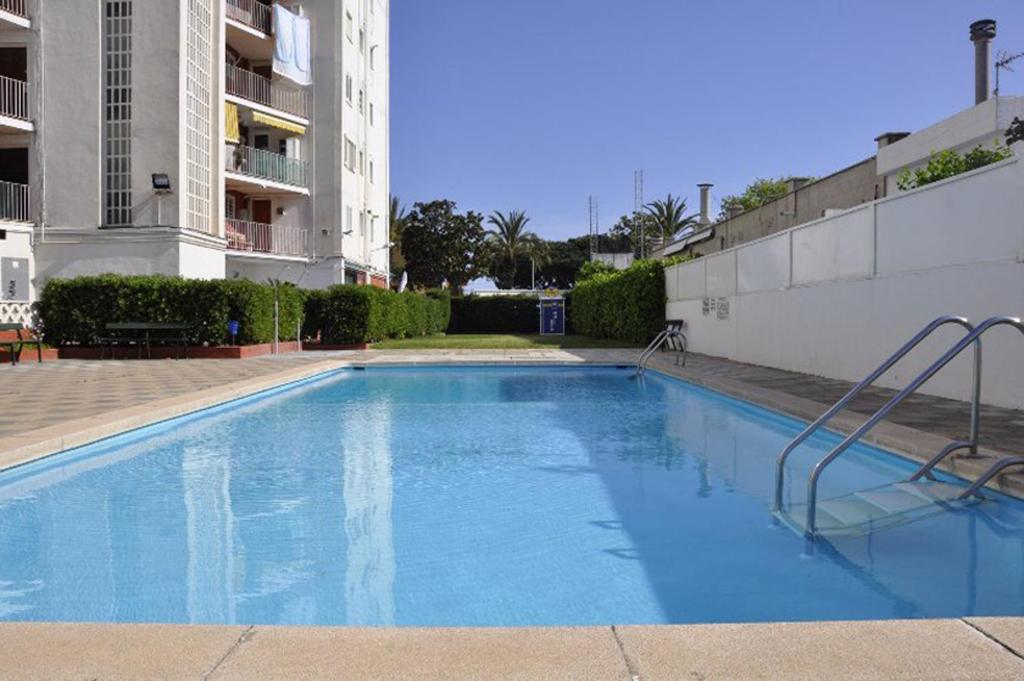 een groot blauw zwembad voor een gebouw bij Apartamento Felicidad in Malgrat de Mar