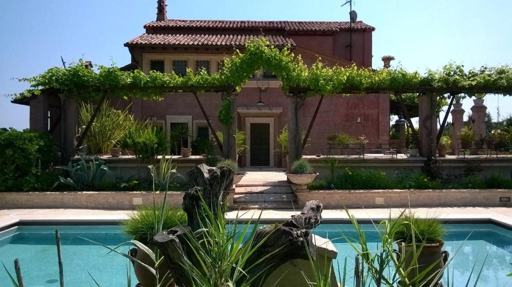 a villa with a swimming pool in front of a house at B&B Posserle in Padenghe sul Garda