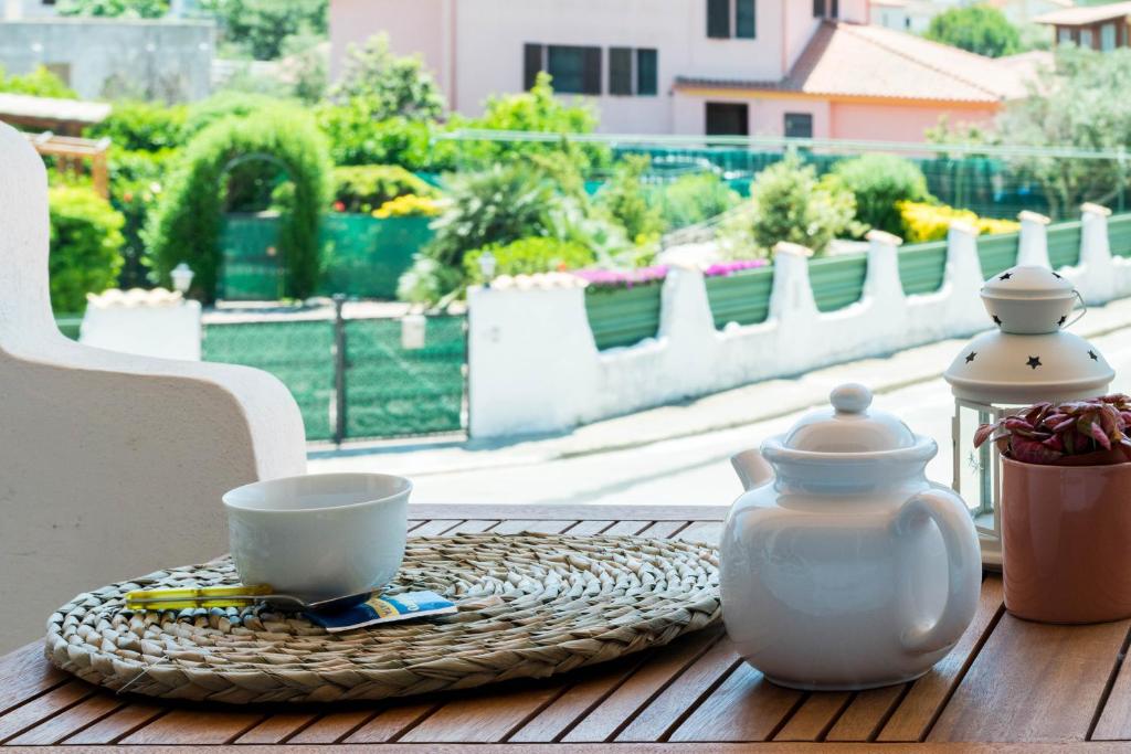 einen Tisch mit einer Tasse und einer Teekanne darauf in der Unterkunft Spazioso Appartamento al Mare con Giardino in Capoterra