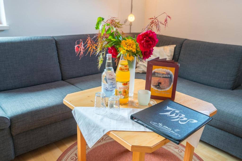 a coffee table with a bottle of beer and flowers on it at Ferienwohnungen Fischerhaus - direkt am See in Millstatt