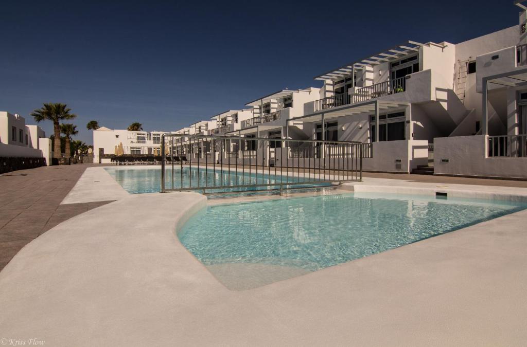 una piscina frente a un edificio en Los Gracioseros BUNGALOW 2 en Puerto del Carmen