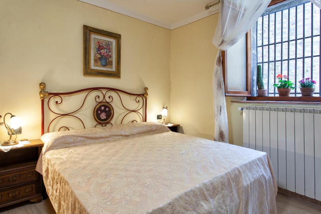 een slaapkamer met een groot bed en een raam bij Il Nido Di Asia in Cortona