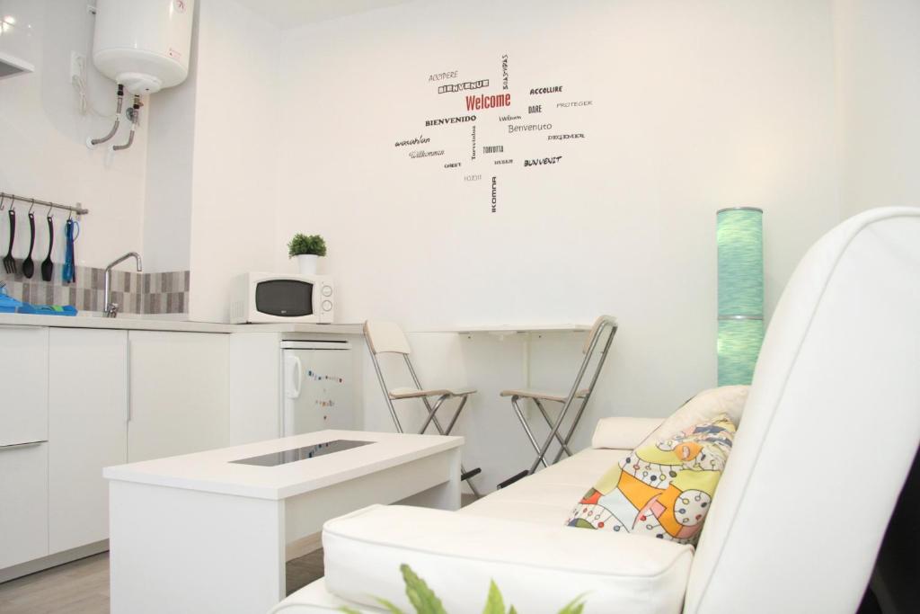 マラガにあるTG FreshApartments by Bossh! Apartmentsの白い椅子とキッチンが備わる白い部屋