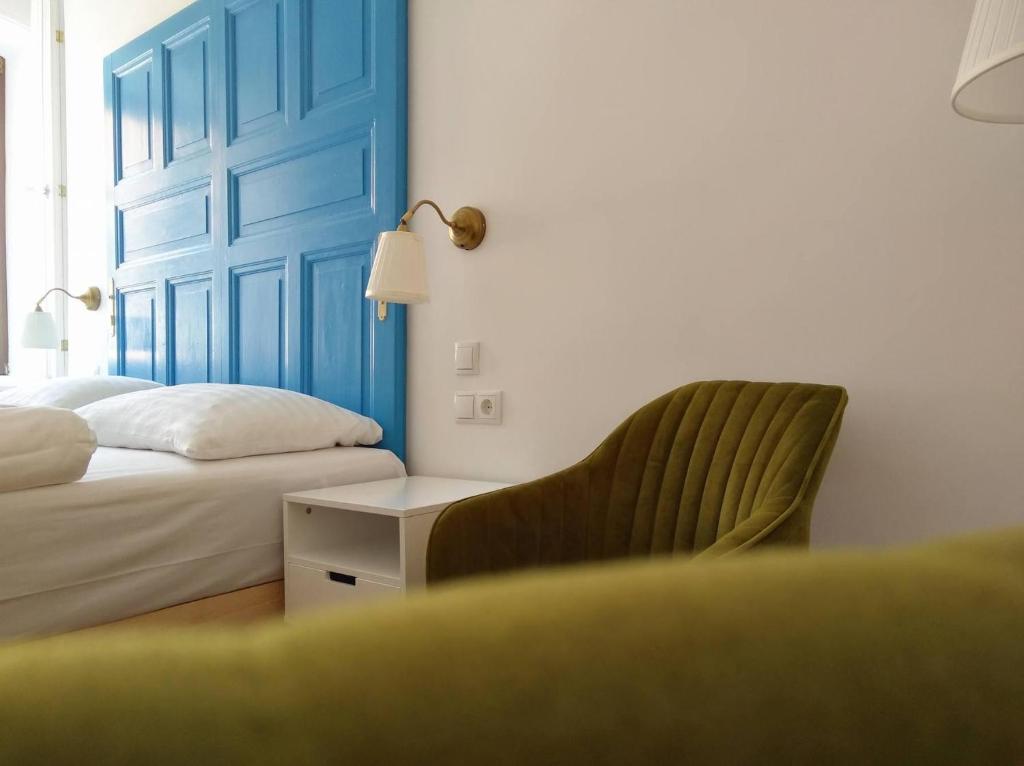 a bedroom with a bed and a chair and a window at Kirchenwirt Dependance Südsteiermark in Ehrenhausen