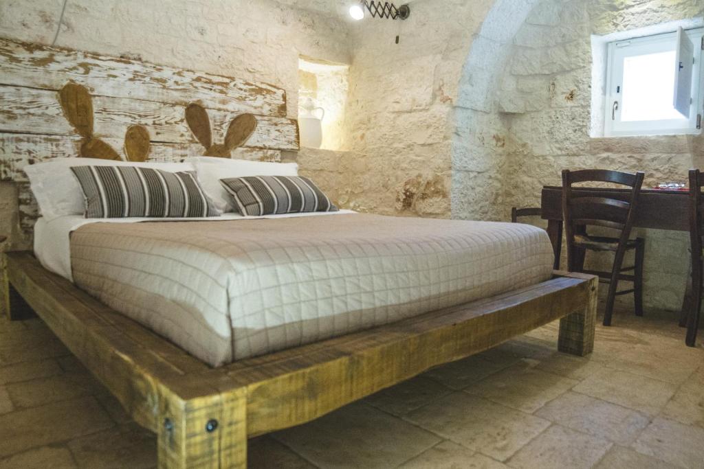 - une chambre avec un lit dans un mur en pierre dans l'établissement Villa Sardedda, à Locorotondo