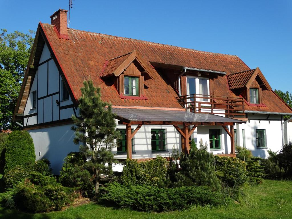 une maison blanche avec un toit rouge dans l'établissement Gospodarstwo Agroturystyczne Zielone Wzgórze, à Budry