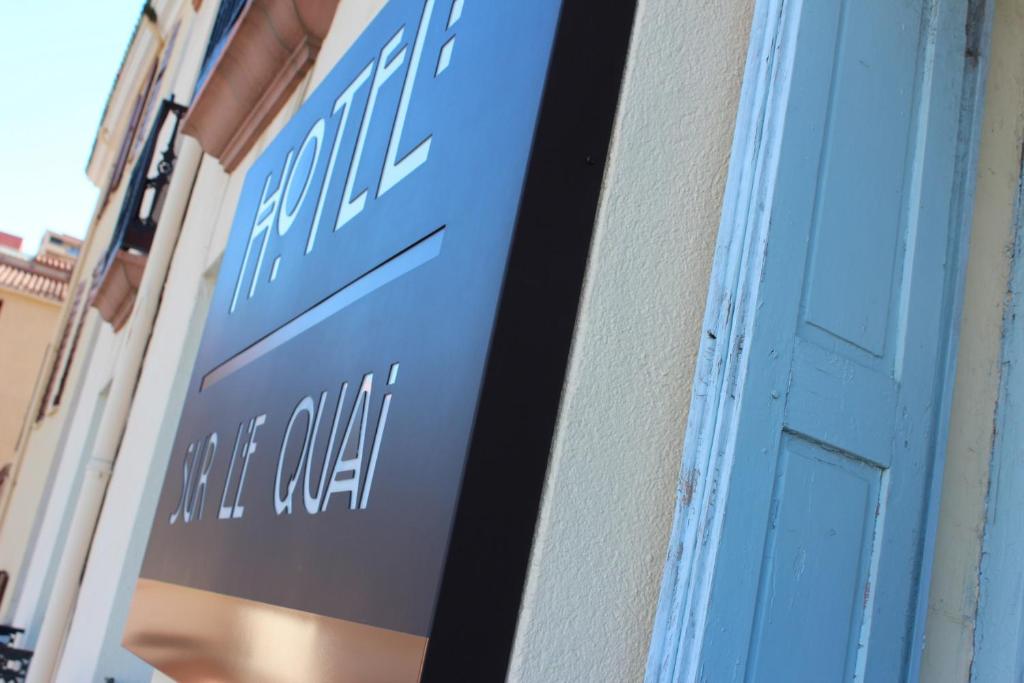 a blue sign on the side of a building at Hotel Sur Le Quai in Port-Vendres