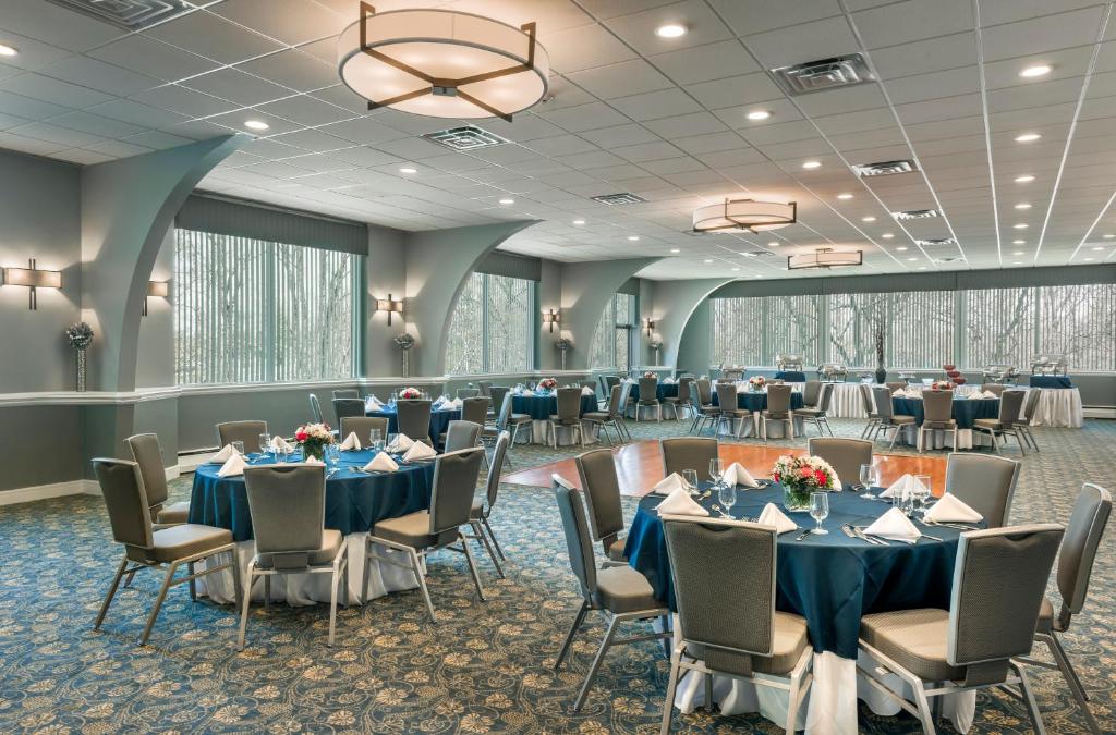 KenilworthにあるThe Kenilworth Hotel - Newark Airport Westの青いテーブルと椅子が備わる宴会場