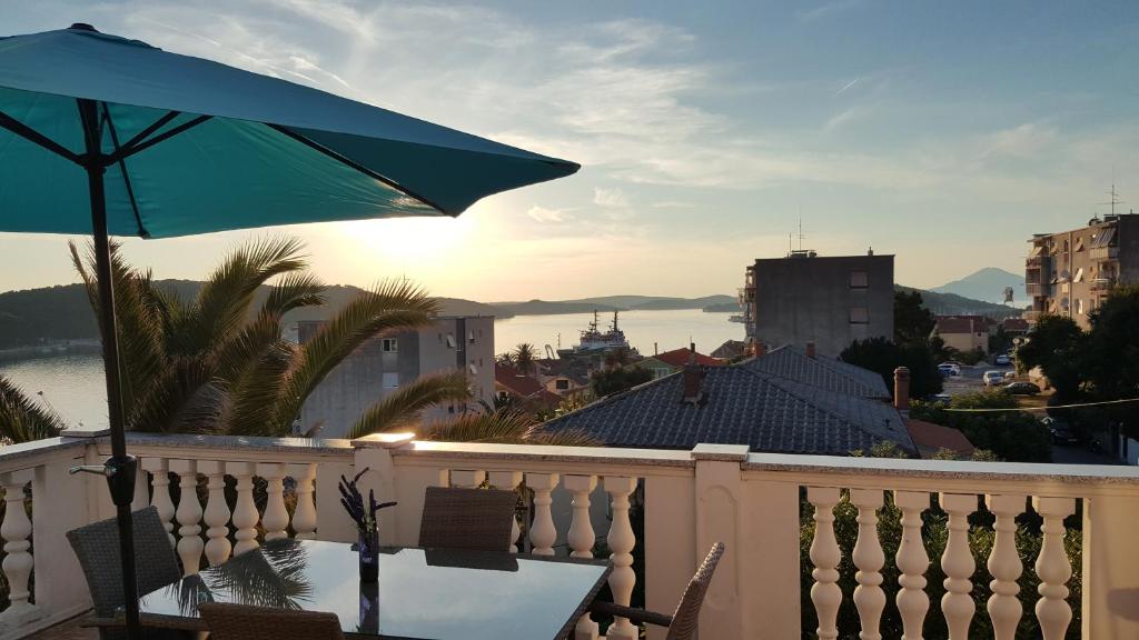 - Balcón con mesa y sombrilla en Apartments Jovic, en Mali Lošinj