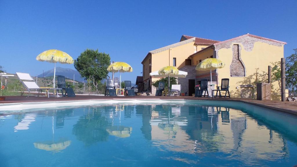 a swimming pool in front of a house at Il Casale Dei Ciliegi in SantʼOmero
