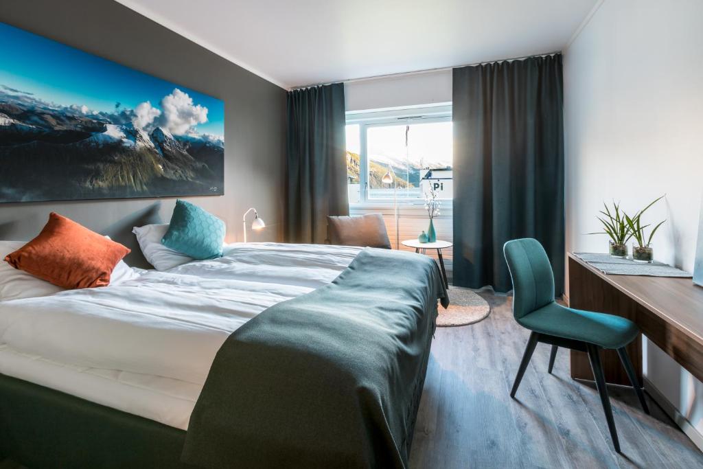 ストランダにあるStranda Hotelのベッドとデスクが備わるホテルルームです。