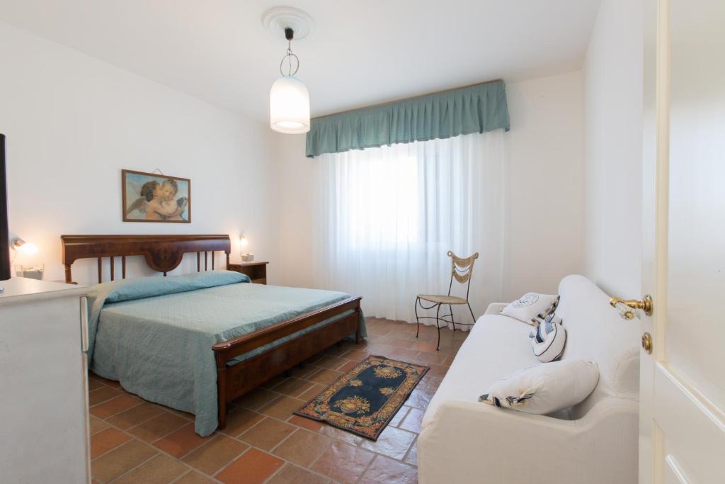 - une chambre avec un lit et un canapé dans l'établissement Villa Milù, à Torre San Giovanni