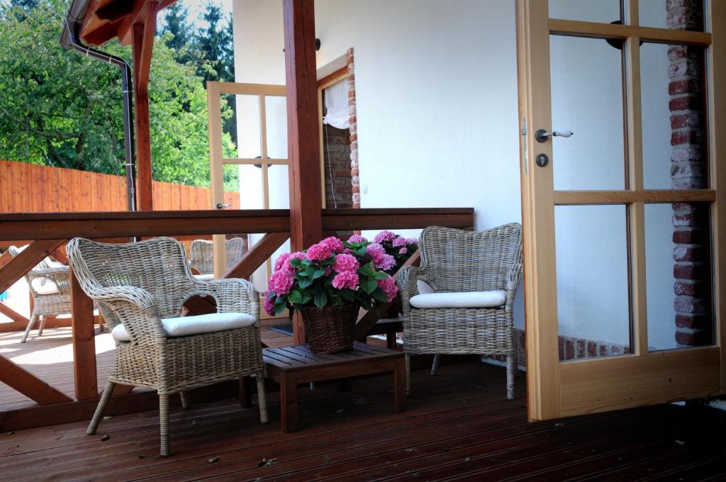 un porche con 3 sillas y un jarrón de flores en Starý Svět en Votice