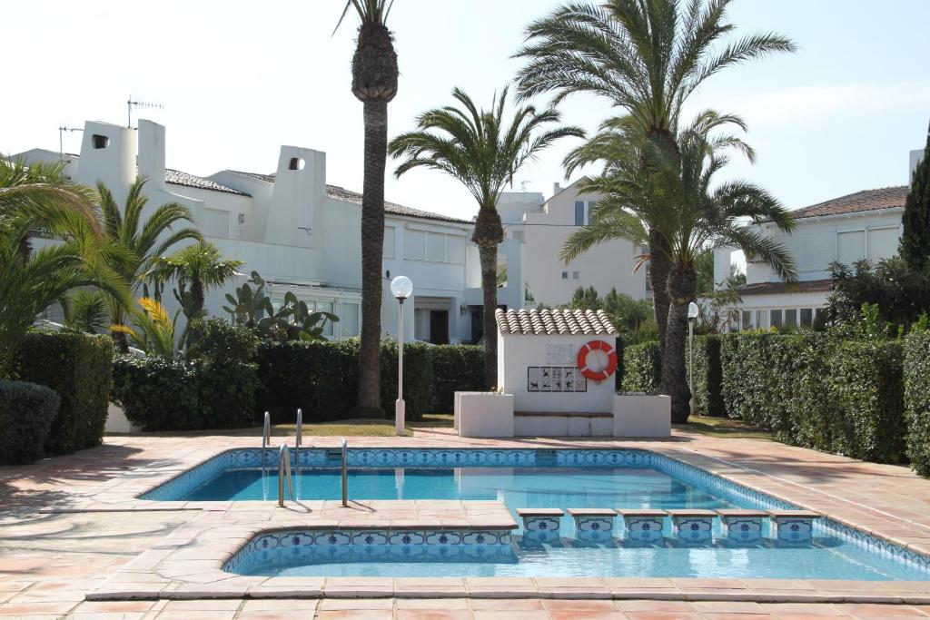 einem Pool vor einem Gebäude mit Palmen in der Unterkunft Ferienhaus mit Pool, primera linea in Denia