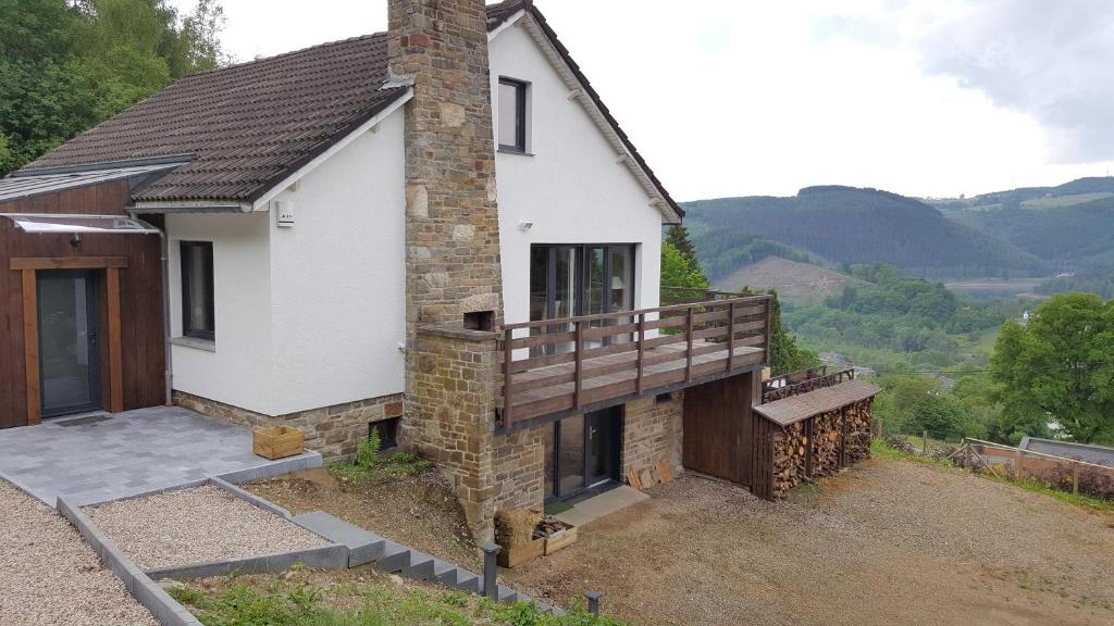 uma casa com um alpendre e uma varanda em Le Chalet de Lancre em Stavelot