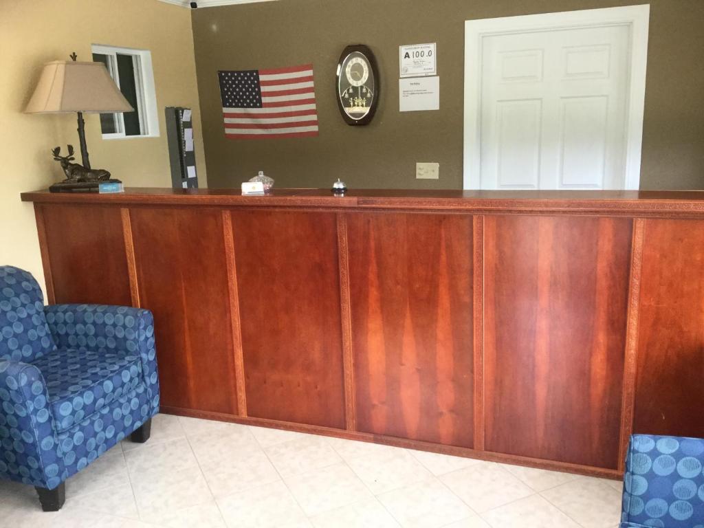 a reception desk with an american flag on the wall at Murphy Motel in Murphy