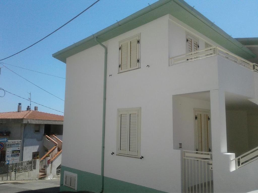 カーラゴノネにあるCasa Verdeの緑の屋根と窓が2つある白い家