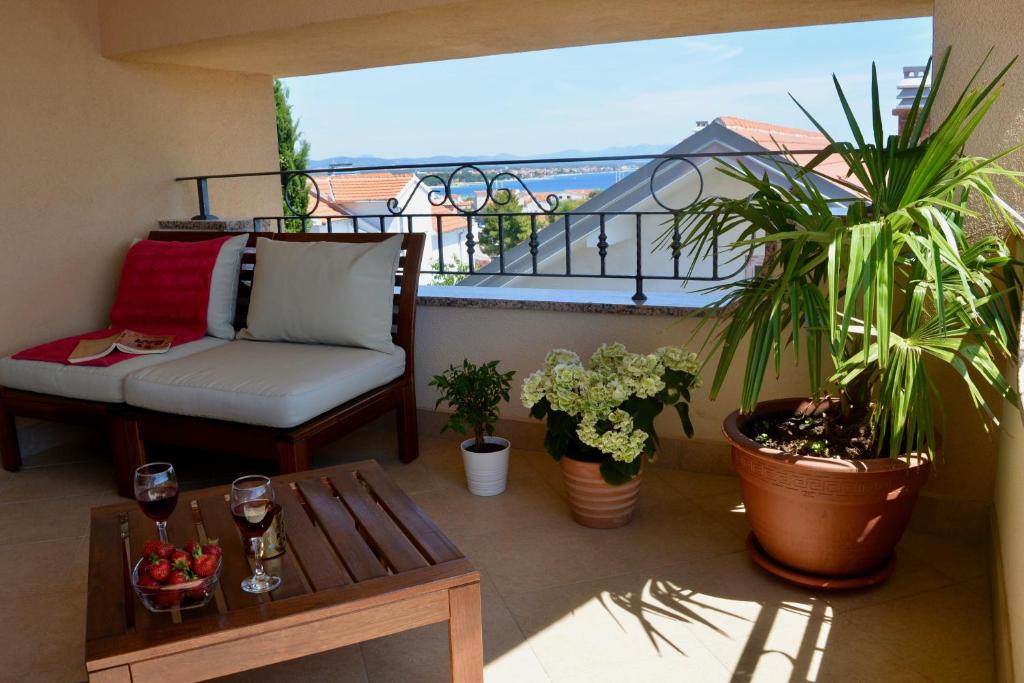 a balcony with a couch and a table and plants at Iva Apartmani in Vodice