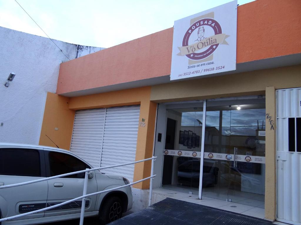 a car parked outside of a store with a car parked outside at Pousada Vó Otília in Juazeiro do Norte